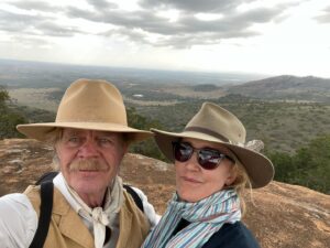 William H. Macy Instagram - Our routine was to get up early (5:30 or 6:00) and have a coffee. After our morning ride we’d have a huge sumptuous breakfast. The staff would fill two basins of hot water, which sat on tripods outside our tents so we could wash our faces.  Our horses were already tacked up and our morning ride would begin at about 7:00.  Our rides would last two to three hours.  Simon led our party and Daisy or Rosie would take the rear.  Simon carried a bullwhip which he could make sound like a gun shot. The first morning, as the trail led us through tall brush on both sides, Simon called back that if anything rushed us, we should turn our horse and go back the way we came with “some dispatch”. Now to me, that raised a lot of questions, but everyone just nodded and kept riding so I did too.
 
Felicity and her brother had ridden across the Maasai Mara on previous safaris, but we were in Laikipia, which is the hill country in north west Kenya.  We would cross great plains and then climb into the hills which gave us some breathtaking views. Simon and our Maasai guide, Netti, were astounding in their ability to spot game, and they had encyclopedic knowledge of everything we saw.  Simon would suddenly shout “Fish Eagle!”. And I would stare at a black lump in an Acacia tree wondering if I was looking in the right place, and then this monstrous bird, which looks a lot like our Bald Eagles, would open his massive wings and glide effortlessly over us.  Or Simon would reign his horse and whisper, “elephants”. And I would scour the bush not seeing any elephants. Until one moved.  And then I’d see seven elephants.  And they are big.  I mean really big.  Even the little ones are big. I feel stupid saying elephants are big – we’ve all been to the zoo, but when you’re in the cage with them, they get a lot bigger.  They are such improbable animals with their kind wise faces and their adorable giant babies, that you have to remind yourself they kill a lot of people every year.  Cape buffalo kill even more people and we saw a lot of them too.  But because there were twelve of us on horseback, and Simon had his bullwhip, I didn’t ever feel we were in real danger.  Then we saw the lions.