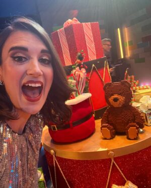 Amy Corbett Instagram - Behind the scenes photodump from @legomastersfox Celeb Holiday Bricktacular 🎄🎅🌟
Have you watched yet? If not, what are you waiting for??? Find it on Hulu 🤩Also…how awesome is all the brick built scenery on set!?! Thought you might like a closer look 🙌
📸 Getting my elf on - comfy slippers and clipped up curls 😂
📸 Brickbuilt fireplace 
📸This teddy bear was a personal fave 
📸Beautifully crafted sleigh 
📸Brickmaster having a blast on set
📸Family photos on the mantelpiece 😂
.
.
.
#legomasters #legomastersfox #legomastersusa #lego #legobuild #holidaybricktacular #celeb #build #play #legobuilders #afol #christmas #christmasspecial #holidayspecial