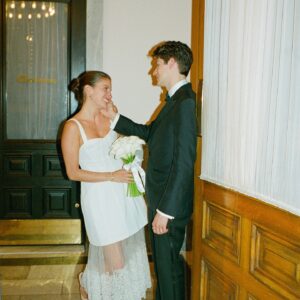 Barton Cowperthwaite Instagram - We were married in the Solarium next to the Piano Bar at the Hotel Chelsea. Choosing the Chelsea was an easy decision. It’s iconic, filled with art and history. I grew up on 22nd between 5th and 6th, and remember it in its late 90’s crumbling glory. The Solarium, small and perfect for our 35 guests, has a beautiful skylight running the length of the room. Decorated with plants and greenery, it was perfect as it was, requiring minimal decoration.

Our best friend Sammy (Bart’s best friend since birth) who knows us as individuals and as a couple better than anyone else, officiated the ceremony. It felt comfortable, relaxed, and unfussy. Our violinist played as we each walked down the aisle with our parents. The three of us stood in front of an arch I constructed from wooden dowels, tissue paper flowers from Etsy, Velcro, and hot glue. We were flanked by two bunches of my favorite Allium flowers. We each took a long moment to take in the space before our vows. We wanted to be as present as possible. 

After the ceremony, we had a champagne toast, and Bart’s brothers each said a few words. Our guests stayed for a cocktail hour while we left to do photos in our room. We left the Hotel Chelsea and went to the West Village with our photographers. Standing on a corner next to a tipped-over trash can for 15 minutes, trying to hail a cab, we were met with honks and cheers. It was a quintessential New York moment, a reminder that the city stops for no one.

We walked around the West Village, taking photos at all our favorite neighborhood spots. We stopped by Grove Apothecary to see our pharmacists, who have always taken such good care of us. We visited the Jane laundromat, where Bart has made friends with everyone who works there. We were all heartbroken when he got sick, but no one was as crushed as our friends at the laundromat. We dropped in at Casa Magazines, where Bart buys copies of the magazines he’s published in. This community is a part of our everyday lives. They’ve made our New York City feel like a close knit small town. Their kindness and care got us to the other side of a terrifying time, and we wanted to share a piece of the other side with them.