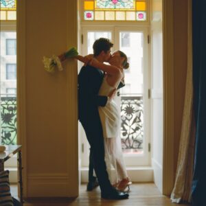 Barton Cowperthwaite Instagram - We were married in the Solarium next to the Piano Bar at the Hotel Chelsea. Choosing the Chelsea was an easy decision. It’s iconic, filled with art and history. I grew up on 22nd between 5th and 6th, and remember it in its late 90’s crumbling glory. The Solarium, small and perfect for our 35 guests, has a beautiful skylight running the length of the room. Decorated with plants and greenery, it was perfect as it was, requiring minimal decoration.

Our best friend Sammy (Bart’s best friend since birth) who knows us as individuals and as a couple better than anyone else, officiated the ceremony. It felt comfortable, relaxed, and unfussy. Our violinist played as we each walked down the aisle with our parents. The three of us stood in front of an arch I constructed from wooden dowels, tissue paper flowers from Etsy, Velcro, and hot glue. We were flanked by two bunches of my favorite Allium flowers. We each took a long moment to take in the space before our vows. We wanted to be as present as possible. 

After the ceremony, we had a champagne toast, and Bart’s brothers each said a few words. Our guests stayed for a cocktail hour while we left to do photos in our room. We left the Hotel Chelsea and went to the West Village with our photographers. Standing on a corner next to a tipped-over trash can for 15 minutes, trying to hail a cab, we were met with honks and cheers. It was a quintessential New York moment, a reminder that the city stops for no one.

We walked around the West Village, taking photos at all our favorite neighborhood spots. We stopped by Grove Apothecary to see our pharmacists, who have always taken such good care of us. We visited the Jane laundromat, where Bart has made friends with everyone who works there. We were all heartbroken when he got sick, but no one was as crushed as our friends at the laundromat. We dropped in at Casa Magazines, where Bart buys copies of the magazines he’s published in. This community is a part of our everyday lives. They’ve made our New York City feel like a close knit small town. Their kindness and care got us to the other side of a terrifying time, and we wanted to share a piece of the other side with them.
