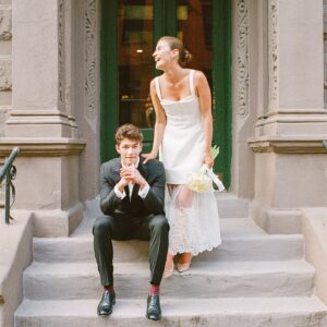 Barton Cowperthwaite Instagram - We were married in the Solarium next to the Piano Bar at the Hotel Chelsea. Choosing the Chelsea was an easy decision. It’s iconic, filled with art and history. I grew up on 22nd between 5th and 6th, and remember it in its late 90’s crumbling glory. The Solarium, small and perfect for our 35 guests, has a beautiful skylight running the length of the room. Decorated with plants and greenery, it was perfect as it was, requiring minimal decoration.

Our best friend Sammy (Bart’s best friend since birth) who knows us as individuals and as a couple better than anyone else, officiated the ceremony. It felt comfortable, relaxed, and unfussy. Our violinist played as we each walked down the aisle with our parents. The three of us stood in front of an arch I constructed from wooden dowels, tissue paper flowers from Etsy, Velcro, and hot glue. We were flanked by two bunches of my favorite Allium flowers. We each took a long moment to take in the space before our vows. We wanted to be as present as possible. 

After the ceremony, we had a champagne toast, and Bart’s brothers each said a few words. Our guests stayed for a cocktail hour while we left to do photos in our room. We left the Hotel Chelsea and went to the West Village with our photographers. Standing on a corner next to a tipped-over trash can for 15 minutes, trying to hail a cab, we were met with honks and cheers. It was a quintessential New York moment, a reminder that the city stops for no one.

We walked around the West Village, taking photos at all our favorite neighborhood spots. We stopped by Grove Apothecary to see our pharmacists, who have always taken such good care of us. We visited the Jane laundromat, where Bart has made friends with everyone who works there. We were all heartbroken when he got sick, but no one was as crushed as our friends at the laundromat. We dropped in at Casa Magazines, where Bart buys copies of the magazines he’s published in. This community is a part of our everyday lives. They’ve made our New York City feel like a close knit small town. Their kindness and care got us to the other side of a terrifying time, and we wanted to share a piece of the other side with them.