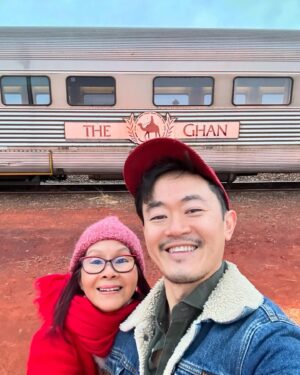 Benjamin Law Instagram - Ticking off an all-time bucket list item for Mum’s 70th birthday … BY TAKING HER ON THE FRICKIN’ GHAN. 
 Feeling damn lucky to travel close to 3000km through the heart of the continent on such an iconic railway, starting in Adelaide on Kaurna Country, then chasing sunrise at Marla on Anangu Pitjantjatjara Yankunytjatjara Land, having stunning off-train nature experiences at Mparntwe (Alice Springs) and Katherine on Jawoyn Country, before finally pulling into Darwin on lush Larrakia Country. 

It’s wild. You honestly can’t quite comprehend the scale of Australia until you experience it like this. 

But what was really staggering for this daughter of a restaurateur (Mum) and son of a restaurateur (me) was the all-inclusive* wine list and menu of fine-dining quality local fare (think: crocodile dumplings, local barramundi, buffalo massaman curry, mango parfait) they served up every day. We’re still processing how these peeps make food this good on a moving vehicle. 

Shout out to the entire Ghan crew who gave us the Gold Service (literally) treatment, especially Yohan, Rami, Darlene, Ralph and Imogen for taking extra special care of Mum. 

And massive thanks to the utter legends at @journeybeyondrail for making a lifelong dream of Mum’s come true. 

If you’re considering one of their iconic trips between Adelaide and Darwin (The Ghan), Sydney and Perth (Indian Pacific), Brisbane and Adelaide (Great Southern) or Adelaide and Melbourne (The Overland), follow them on Insta for inspiration and travel porn. 

Can’t recommend it enough. 

Oh, and happy birthday to the Ghan too. Lookin’ good for a gal who’s just turned 95.

*N.B. “All-inclusive” is now my safe word. 

#journeybeyondrail #theghan #australiabytrain #gifted