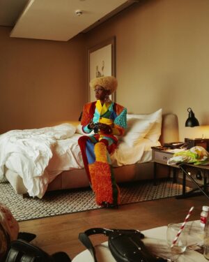 Black Peppa Instagram - BTS shots before heading to @frolovheart SHOW. Thank you @thelondoner 💖

LFW- LOOK 4- Wearing custom @christopherniari to attend the @frolovheart SHOW. Had this concepts for months where I’d use various fabrics with different textures particularly bathroom rugs, felt, suede, faux leathers and furs to create a groovy tailored high waisted pants suit. For this LFW it was also my priority to showcase more black hair styles and desired to style a blonde Afro myself. This was the first time I’ve styled any wig and was quite proud of the end result I must say.

Photographer: @kimlangstudio 
MUA: @jackoliverx using @theunseenbeauty 
Full look: @christopherniari 
Hair by me
Earrings: @nobasicbombshell
Money Nails by @nailsanthonys
