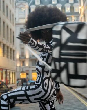 Black Peppa Instagram - London Fashion Week Look 1 - Part 1
LCF POSTGRADUATE SHOW 🦓

📸 @ivantruewizard 
MUA: @jackoliverx 
Catsuit constructed by @itsjust_joe and fully hand painted by moi 
Waist: corset by @misty_couture 
Heels: @hummingbirdheels spray painted and painted by me including handbag bought from a charity shop.

Makeup
@trixiecosmetics Hotline gel liner white on eyelids
Foundation: @kvdbeauty 
Setting powder and spray : @onesize 
@weledauk 
@maccosmeticsuk