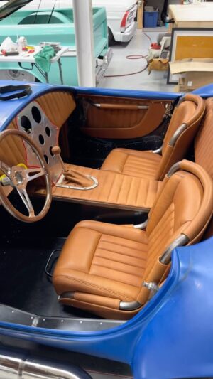 Bryan Fuller Instagram - Our #FactoryFive #Cobra interior is all prefabbed and ready to go to @rockfordcustompaint to squirt some blue on it!  This was a #design challenge to build something unique with so many thousands built over the past 60 years, but again I think we pulled it off.  We wanted to keep the raw fabricated feel but soften up the passenger area.  If you’ve ever been in one of these it’s knarly and not a luxury ride to say the least.  Padding the dash sets this one apart along with exposed hinges, custom fabricated seats, and that gorgeous @mooreandgiles leather.  Great job by the entire team on this one.  If you have a project that needs an exclusive and special #custominterior keep us in mind!  #fullermoto #trimshop #interior #cobrainterior #thehogring #mooreandgiles #shelbycobra #caffeineandoctane #fabrication #triplecrownofrodding