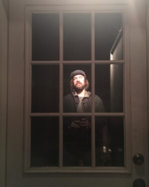 Charles Halford Instagram - Reflecting on.... My self image reflecting off a fragile surface under very a specific light. 
I wonder, the more specific a self image, the the more fragile, and tricky to illumine..? And the more difficult to maintain with any sort of clarity or focus.

#Wonderful
#tbt
#reflection 
#selfie 
#window 
#door 
#night 
#nightphotography 
#goodhat
#findyourlight 
#goodnight