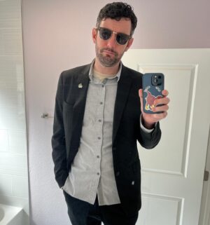Colin A. Borden Instagram - All black. Dumpster fire lapel pin. Dinosaur on the phone case. Let’s get this bread.