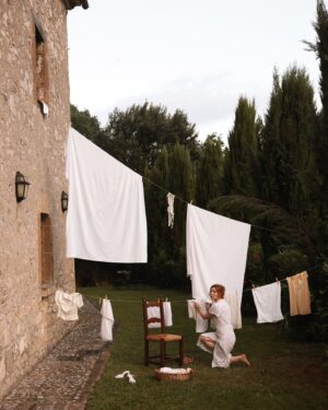 Courtney Halverson Instagram - It’s been awhile, but I still remember this unkind message I recieved. I’d shared my laundry drying in a hotel room in a photo and received a message to the effect of “this whole romanticizing thing is so insufferable. It’s just clothes drying in a bland room”. But I’ve always felt - there’s a kind of magic in finding the beauty in the ordinary, isn’t there? 

I think, if nothing else, my camera roll is a testament to that. Sure, there are the big moments; the sweeping views, the vacation photos, the special occasions and dressed up events. But in a much greater quantity there are the “in-betweens” as I call them; the flowers and weeds growing in equal measure on our hillside, the pasta I threw together for lunch that looked nice on our windowsill, my morning coffee in bed, and yes - photos of the way the light happened to fall on my laundry drying one very ordinary day.

So while this isn’t exactly an ordinary moment (hello dreamy laundry line in Tuscany) I hope it serves just a little as a love letter to all the “in-betweens” I capture and treasure.
.
.
.
photos by the lovely @leanneansar | wearing @shopdoen and @rouje 🤍 #romanticstyle #underthetuscansun #feminineenergy #laundryline 
.
.
ps : so many of you have asked and I’m pleased to share that my locket with @monicarichkosann is coming back this month. It’s been a dream to see how many of you fell in love with it the first time, and I wear mine daily. So thrilled to be able to share it again! 🐚
