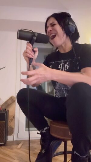 Cristina Scabbia Instagram - Random raw take from the @lacunacoilofficial “Hosting the shadow” rec session.
You are literally by my side in the room.

Fun facts about me as a singer: 

-I always prefer to sit as I am recording. It’s my thang.

-I use LOUD, I mean LOUD volumes in my ears, I need the full vibe of the song and I always liked it this way.
@maki hates me for that 😝

- I never like to hear my voice in videos or records, either sung or spoken (but I’m glad when others like it)

-I sing in a very 🇮🇹 way, I gesticulate A LOT (it helps me to reach the right note) 🤌🏻🤌🏻🤌🏻

Wanna hear more of the raw stuff?