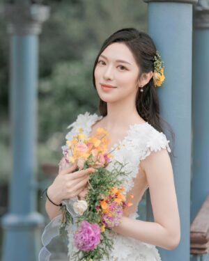 Crystal Fung Instagram - 這身造型我非常喜歡💖但不知在什麼地方拍攝效果最好。
攝影師就提議只有一個地方才是這條裙子的perfect match。
當我到達時，才發現這裡是婚照拍攝的熱門場地👰🏻‍♀️

這讓我突然想起自己即將為一位認識多年的好朋友擔任婚禮伴娘。
這將是我人生中第一次做伴娘💐
我心想：如果能穿上這條漂亮的裙子出席婚禮，那就太完美了。

攝影師聽到後，笑著說：「你今天這身白裙配上鮮花的造型，更像是一位花女呢！」🌸
我也忍不住笑了出來🤭
雖然我對他的攝影技術很有信心，
但我不禁懷疑他知道什麼年齡的小朋友才可以擔任花女嗎？

不過我還是忍住，沒有問出口。
因為看到他在大熱天下為我拍攝🥵
我怕他會生氣而拋下相機，
那我就束手無策了。
所以最終答案到底是什麼？
😅

Makeup & Hair : @kayowang 
Dress : @elysianbridal 
Flower : @privatefloralhk 
📸 ： @dreamer317hk