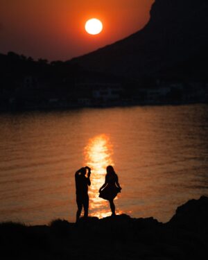 Dominic Arpin Instagram - On rentrait à notre Airbnb pour se doucher entre deux tournages lorsque j’ai aperçu la scène en roulant. Un couple se faisait un petit shooting photo au iPhone devant le coucher de soleil à Kalymnos. Avec la petite île de Telendos en arrière plan, la scène avait des airs de carte postale! J’ai manqué de temps pour aller leur offrir ma photo mais ce serait fou qu’elle se rende jusqu’à eux grâce à la magie des réseaux sociaux! Qui sait? 🤞