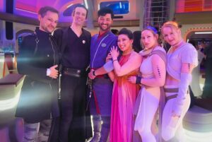 Erika Ishii Instagram - May the 4th be with you! Last year, my crew and I booked passage on the Star Cruiser Halcyon. It was a transcendent immersive experience and immensely inspired me in my storytelling. Thank you @car0mur for introducing us to the colorful characters onboard, and to the cast and crew who made our stay unforgettable. My friends and I boarded with elaborate backstories and costumes and every person aboard met us at our level and helped us live out our dreams on a galaxy far, far away. ♥️

Meet the motley crew of the Arabesque, a humble merchant ship that can help acquire anything you need.  Our pilot always said, “She doesn’t look like much, but out there in the stars, she dances.” I was Captain Lane Vizla (I borrowed the name of the SWTOR character I voice!) Socialite and pulp holo-vid actor by day, and by night a scoundrel using social connections to aid the Resistance. I hand painted my gown with Aurabesh: JUSTICE, TRUTH, LOVE.

Also today I can announce another new credit in a Star War: I’m a friendly Scoundrel/Smuggler in LEGO Fortnite!