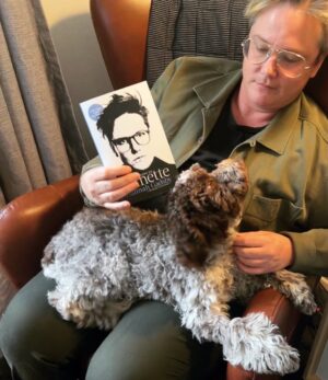 Hannah Gadsby Instagram - Big news day…I wear green now, I have a new puppy, and my hardcover book is now soft. …I repeat, PAPERBACK BOOK ON SALE NOW. Smaller, lighter, cheaper…all the things you want in a book. And a puppy. (BTW their name is Nuna Riverdale Velcro Roomba.)