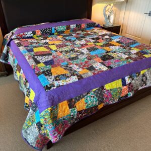 Harvey Fierstein Instagram - Just completed this DAY OF THE DEAD quilt. I love every one of the fabrics even if I should have shown some restraint. So, to hold it all together, I added the purple border and quilted it with 4 DOTD snakes chasing one another around the quilt. The rest of the quilting is Sugar Skulls. Hard to see, but they are there!
