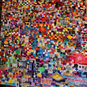 Harvey Fierstein Instagram - Someone, some very generous someone, sent me a box of her tossed off scraps. I opened the box and my mind was blown. I had to make something of them ... 
My aim was to throw judgement away and just grab tiny scraps sewing them together and seeing what they did for one another. If I liked a color, I sewed it on. If I liked a print, onto the quilt it went. I cut very little, (the fussy cut flowers are an exception), but tried to use the scraps as they came out of the pile.
The technique was "quilt as you go" style, on the long arm, and it was so much fun to make. it was so freeing! I was in heaven the entire time. Even binding it was fun since I just kept using the scraps. And... It's HUGE! 120" X 106"
I love it.
But my favorite detail can be seen on the lower right hand corner. it's a smile covid mask leftover from the baby quilt I made last week.