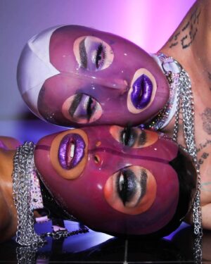 Ilona Verley Instagram - “Don’t get sad, Get Even”
😈😈😈😈
CW! Fake Blood!
😈😈😈😈
Halloween might be over but y’all know @kikiwannakaikai & I had to keep the spookening alive!
😈😈😈😈
Brows: 
@aboutfacebeauty 
Brow Artist in Black Brown
Fractal Glitter Brow in interlude
Eyes:
@morphebrushes Nyane Fierce Fairytale palette 
@litcosmetics Ice Princess Glitter Mix
Lips:
@kvdbeauty Glimmer Veil in Televator (rip to this discontinued fav of mine)
😈😈😈😈
Latex Hoods are from @deadly_couture (lavender one dyed by me!)
Choker’s we’re a harness from @jqclothingltd I stoned and cut up!
Photos by @hauszuk !
😈😈😈😈
#latexhood #latex #blood #fakeblood #purpleeyeshadow #purplehaloeye #purplelipstick #drag #dragqueens