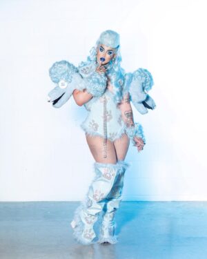 Ilona Verley Instagram - “Walk your ass on a leash, here's a treat”
🐩🐩🐩🐩
Y’all have been AT ME to get the poodle look back up and I swear I never meant for it to be MIA for so long but I’m very happy to finally be putting it back up, this time with some never b4 seen Polaroid’s!
🐩🐩🐩🐩
This was the one look I got to wear on drag race (other than promo and entrance haha) that really showcased my brand and the type of drag I love to do, it made me so happy how much everyone else loved it!
🐩🐩🐩🐩
Hair: @ardawigscanada styled by me!
Outfit: @hauszuk (with the help of many that stoned all the paw prints (tbh I legit forget who all helped rip)
Hot: @johnnywalkersfitness 
🐩🐩🐩🐩
#canadasdragrace #poodle #poodlefashion #poodlewig #poodlehair #bluepoodle #trans #queer #pvc #pvcfashion #pvcclothing