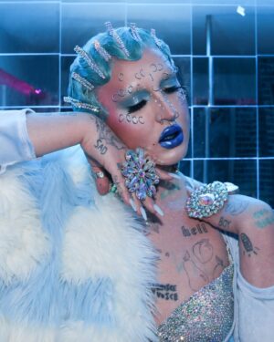 Ilona Verley Instagram - “They can kiss the ring
But they never take the crown”
💍💍💍💍
Haven’t snapped on a serve in a minute so figured I’d go back to my roots & recreate one of my fav @brookecandy Opulence era looks that I’ve always wanted to put a pastel spin on!
When I first started doing drag recreating Brooke’s looks was such a big part of finding my own style so it was really fun to do this now as an inspired by and less of an exact recreation!
💍💍💍💍
Hair is @premiumlacewig cut, styled & colored by me!
Face piercings by me!
ILONA fur custom by @hauszuk
(As well as the velour dress!)
Photos by @pinkponyboy & @coco_klein
Stoned bra & corset @poutine_queen
💍💍💍💍
#opulence #brookecandy #fingerwaves #blueeyeshadow #abcrystal