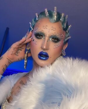 Ilona Verley Instagram - “They can kiss the ring
But they never take the crown”
💍💍💍💍
Haven’t snapped on a serve in a minute so figured I’d go back to my roots & recreate one of my fav @brookecandy Opulence era looks that I’ve always wanted to put a pastel spin on!
When I first started doing drag recreating Brooke’s looks was such a big part of finding my own style so it was really fun to do this now as an inspired by and less of an exact recreation!
💍💍💍💍
Hair is @premiumlacewig cut, styled & colored by me!
Face piercings by me!
ILONA fur custom by @hauszuk
(As well as the velour dress!)
Photos by @pinkponyboy & @coco_klein
Stoned bra & corset @poutine_queen
💍💍💍💍
#opulence #brookecandy #fingerwaves #blueeyeshadow #abcrystal