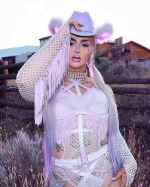 Ilona Verley Instagram - “You were a mirage, you’re not really there”
🐎🐎🐎🐎
Inspired by @slayyyter & the cowboys music video!
🐎🐎🐎🐎
This look was originally made for me a few years ago by @connormccalden who did up the chaps/ bra & gloves for me when I was in Toronto for a few months and running out of outfits at the time!
I later made the hat and the bodysuit to go with it & @hauszuk helped me stone everything! 
🐎🐎🐎🐎
I’m so happy to have finally gotten to shoot this look & to do it with my incredible mom @sandiverley who took off a whole weekend to drive us up home to the canyon and literally camp until it was cool enough for us to drive to the ghost town to actually shoot… our one day trip turned into a 3 day adventure!
THANK YOU MOM!
🐎🐎🐎🐎
Hair was done for me the MORNING of by @the.girlfriendexperience
Also a big shout out to sheisbliss for helping me stone and get myself together that morning as well!
Hat was originally from @rockin_cowboy_clothing_company painted and transformed by me! (Reel coming soon on the DIY) 
Boots were from @onlymaker_shoes transformed by sheisbliss & myself! 
Earrings by @sadndn_ 
🐎🐎🐎🐎
I used to try to be so independent and do everything myself, but the last little bit, I’ve been giving up the perfection complex of wanting to do it all alone & it has helped me see that creating is not only easier but much more rewarding when you work with others, especially the people you LOVE!
The funny thing is to me the most perfect art has been the stuff I’ve done with friends… not the stuff I’ve done alone… (learning lesson for those struggling with giving up control / dealing with the typical artist perfection complex) 
🐎🐎🐎🐎
#cowgirl #cowgirlfashion #cowboyhat #purple #lavenderhair #humanhairwig #drag #dragqueen #purplemakeup #onlymaker #festivalfashion #ravegirl #ravegirls