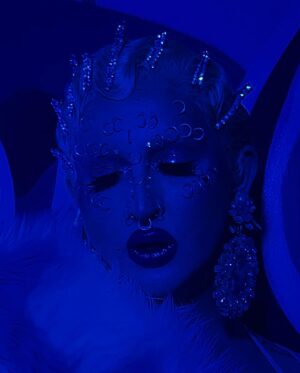 Ilona Verley Instagram - “They can kiss the ring
But they never take the crown”
💍💍💍💍
Haven’t snapped on a serve in a minute so figured I’d go back to my roots & recreate one of my fav @brookecandy Opulence era looks that I’ve always wanted to put a pastel spin on!
When I first started doing drag recreating Brooke’s looks was such a big part of finding my own style so it was really fun to do this now as an inspired by and less of an exact recreation!
💍💍💍💍
Hair is @premiumlacewig cut, styled & colored by me!
Face piercings by me!
ILONA fur custom by @hauszuk
(As well as the velour dress!)
Photos by @pinkponyboy & @coco_klein
Stoned bra & corset @poutine_queen
💍💍💍💍
#opulence #brookecandy #fingerwaves #blueeyeshadow #abcrystal