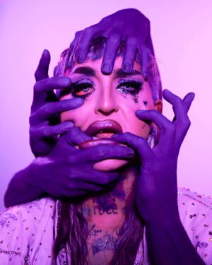 Ilona Verley Instagram - “you don't wanna be changed like it changed me”
✨✨✨✨
TW: Mental Health 
✨✨✨✨
A few years ago I had the idea to do a shoot with colored hands pulling at my face, it was a visual representation of the barriers I face living with OCD. (Swipe to see my OG post that has long been archived…)
When @iiswhoiis dropper the visuals for eat the acid I was so stoked to see her also having a similar concept to suuuuch a powerful song that I felt so much of my own journey in. Great minds think alike and all that! 
As soon as I saw her visuals I knew I wanted to give this concept another shot! 
✨✨✨✨
I’ve been re-navigating a lot of my barriers with my OCD the last few months and coming up with healthier coping skills, re learning what a healthy relationship looks like with my mental health and limiting myself less.
✨✨✨✨
Eyes:
@suvabeauty UV Brights palette
@litcosmetics Party Girl Glitter mix
Brows:
@anastasiabeverlyhills Ebony Dip Brow
Lips:
@maybelline Super Stay Matte Ink in Mover
@limecrimemakeup Mermaids Hi-Lite palette 
✨✨✨✨
Thank you to @hulk_broghen & @coco_klein for being my hands 
Thank you to @megsgiallo for shooting 
Thank you to everyone including mom ( @sandiverley )for helping with the Lighting 
✨✨✨✨
#eattheacid #kesha #hands #meantalhealth #ocd #bodypaint #creativelhotography #teamwork #purple #drag #canadasdragrace