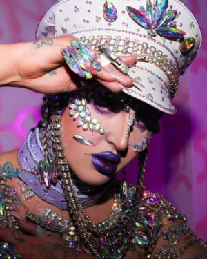 Ilona Verley Instagram - "I'm on everyone's radar
I bet that's why they hate her"
💎💎💎💎
The first time I remember being so inspired that it shaped me as a human was witnessing @brookecandy 's Opulence era unfold in real time.
I was just getting into drag at the time and to this day those looks and that song have had such a grip on me and my aesthetic!
Over the years I've recreated various looks from Brooke's Opulence era, always wishing I had the resources to do them better.
I sat down this week and revisited the OG inspo, the @papermagazine cover and was able to bring my interpretation to life in a way I can finally say I am so proud of! 
If you swipe to the end you'll see the first time I ever tried to take on that look... I was 20 years old, had some dollar store rhinestones and a DREAM. 
💎💎💎💎
Hat by me! 
Jewelry is all left over shit from my drag race package 
Head wrap was made by @evanclayton
Photos by @the.Alma.be
Nails are @kissproducts
💎💎💎💎
#dragrace #ilonaverley #drag #brookecandy #opulence #festivalfashion #festivalmakeup #creativemakeup #ABcrystal