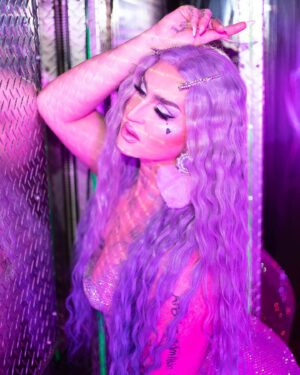 Ilona Verley Instagram - “Life of the party, but the party is finally over”
✨✨✨✨
HELLO INSTAGRAM!
I am so beyond excited to officially announce my new collaboration with @litcosmetics welcome to the stage PARTY GIRL glitter mix!
I wanted to create a shade that was true to my pastel brand & missing from my current glitter collection! 
Party Girl is a mix of different sized glitter to maximize sparkle with a lavender base ranging in holographic / indecent hues to tie into all the fun pastel colors I’m known for serving!
This is my absolute dream shade of glitter & I am looking forward to seeing all the looks you guys create with it! Make sure you hashtag #litcosmeticspartygirl so I can find all your fabulous serves!
✨✨✨✨
PS!!!
Use code ilonaverley-lit20 to save 20% off your entire order when you check out in the @litcosmetics website!!!
✨✨✨✨
Huge thank you to Jodie and everyone at Lit for always supporting my art and showcasing my talent long before I ever made it on tv! 
LOVE YALL SO MUCH!
✨✨✨✨
Couldn’t have put this project together with out the following fabulous friends! So if you like this look and these photos please show some love to the following::::
Photos @megsgiallo 
PARTY GIRL logo also by Meg!
Beaded earrings by @sadndn_ 
Assisted by @theevascarlett 
Big thank you to @numberscabaret for letting us in to shoot in their fab space!
Hair colored and styled by me! 
✨✨✨✨
#drag #instadrag #purplemakeup #purpleglitter #litcosmetics #partygirl #humanhairwig #crimpedhair #trans #browlamination #ilonaverley #canadasdragrace