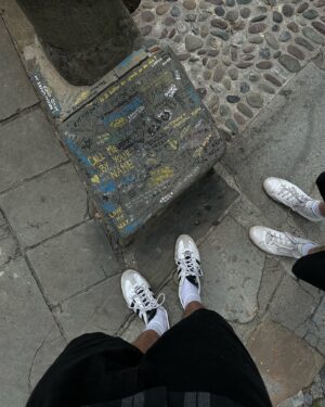 Karel Kovář Instagram - Call me by your name. Oba jsme ho četli i viděli. Jeden z nejkrásnějších filmů je to i díky místům, kde se natáčel. A tak jsme se rozhodli krátký letní výlet strávit v jeho kulisách. Knižní “Somewhere in northern Italy” je ve filmu město Crema a jeho okolí. Po čtyřech nocích a kupě výletů tohle jmenujeme dokonalým letním výletem! V samotné Cremě najdete celou řadu lokací, asi nejznámější jsou dveře jen kousek od náměstí (viz první fotka). Po stopách filmu projedete krásné uličky, náměstí i zákoutí, která byste jinak možná minuli. Samotná Crema je ideální. Tak akorát velká, aby vám tu bylo útulno, tak akorát živá, abyste neměli pocit, že tu chcípl pes. No a pak přichází výlety! Nejdříve Sirmione u Lago de Garda, kam se Elio s tátou a Oliverem vypravili vyzvednout sochu ze dna jezera. Tam vás čeká práva “high season Itálie”, ale archeologické muzeum je oázou klidu a dalším místem, které z filmu dobře poznáte. Zbylé lokace zvládnete z Cremy i na kole, což je samo o sobě ve vztahu k filmu mega ikonický! Jezírko Sorgiva Quarantina je Eliovo “my place”, v reálu je hlavně místem místních, kteří se do ledové vody chodí osvěžit. Další nádhernou lokací je pomník Bitvy na Piavě v Pandinu, kde jsme se ve filmu dozvěděli, že Elio vlastně nic neví. Rozhodně ne o věcech, na kterých skutečně záleží ❤️‍🔥 V samotném městečku rozhodně pes chcípl, ale vesnické kouzlo mu dodaly trhy, kde jsme si málem koupili broskve, ale to už by bylo moc 🍑 No a zlatý hřeb je rozhodně Villa Albergoni. Ta je aktuálně v soukromém vlastnictví, ale její okolí a do dáli čnějící věžička vás okamžitě přenesou do atmosféry filmu, která je... Mimořádně autentická. Okolí Cremy prostě stojí za návštěvu a je krásné, že někdy díky filmům objevíte místa jinak prakticky neobjevitelná. Is it better to speak or die? Rozhodně speak: Pokud milujete CMBYN, užijete si tenhle výlet stejně jako my. We will remember everything 🤍 Later!

#callmebyyourname
