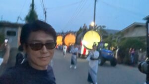 Katsunori Takahashi Instagram - まるで森の奥から生き物のように現れ出でたる大きな大きな太鼓たち。

太鼓の上には何人もの男達が跨り、
五穀豊穣を願うこの米作の地、
長いバチで神様へ届けとばかりに
雨乞いの太鼓を打ち鳴らします。

以前何かの動画で見たそれはなんだかバチャバチャとあまりいい印象がなかったのですが、

実際見ると大違い。

太鼓のリズムも、お囃子の旋律も
勇壮、且つ　どこかなんとも穏やかで

夏の夕暮れに涼。
夜店もひとつもない。
次第に宵闇に包まれてとても素敵です
行列の奥から、太鼓はゆっくりゆっくり近づいてきます。

太鼓を引っ張るトラクター…
まぁコレはコレで農村に今尚残るリアルな風情か😊昔は牛だったのだろう

あたりがすっかり暮れる頃、行列は神社に到着

鳥居の奥の灯りに誘われるように入ってゆくと、、

なんとも神秘的。。。
夢の中に迷い込んだような気分。
サイコーの夏の夕暮れ。

ぜひ一度✨✨✨✨✨

The large drums emerge as if they were living creatures from deep within the forest.
On top of the drums, several men sit astride, striking them with long sticks as if delivering the sound to the gods.

In a video I once saw, the drums seemed rather chaotic and didn't leave a good impression, but seeing them in person is a completely different experience.

The rhythm of the drums and the melody of the festival music are both majestic and somehow very calming.

It cools the summer evening.

Gradually enveloped by the twilight, it is truly beautiful.

Slowly, slowly, they draw near.

The tractors pulling the drums...

Well, this too is a real charm that still remains in rural villages. 😊

In the past, it was probably oxen.

As night falls completely, the procession arrives at the shrine.

Drawn by the lights beyond the torii gate, we enter...

It's truly mystical...

It feels like wandering into a dream.

It really feels like a world straight out of a Studio Ghibli film.

The best summer evening.

Definitely worth experiencing at least once.
