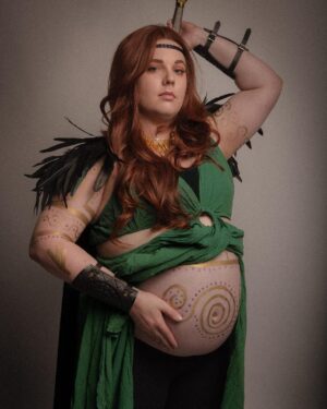 Lindsay Jones Instagram - The photos are in from my second maternity shoot and THEY’RE AWESOME! I wanted to pay homage to Freyja (Freya), Norse goddess of love, fertility, war and death, who is also a mother of two with Odr! Her colors are gold and green, which I implemented into the costume and body paint. Complete with her Brisingamen, feathered cape, sword and shield, she is ready to slay her enemies and her lovers. 
HUGE thank yous to @jonrisinger @texasdelarosa and @andy_blanchard for making this dream of mine a reality! Jon had the brilliant idea to use filters to give them a painted parchment feel. Instagram doesn’t even do these justice. I will be posting more! ❤️