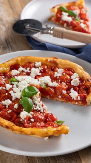 Ludovica Gargari Instagram - 🍅 Tarte tatin pomodorini, feta e basilico…uno spettacolo😍😍 @lulugargari Resident Chef Creator & @giallozafferano 

Ingredienti:
250 g di farina
50 g di olio extravergine di oliva
100 g di acqua ghiacciata
sale 

200g pomodorini
350 g di pomodorini ciliegia
qb senape
20g di zucchero di canna
20g olio
1 spicchio d’aglio
basilico fresco
qb sale
50g feta 
qb Basilico

In un mixer frullare la farina con l’olio il sale e l’acqua ghiacciata. Far riposare in frigo per almeno 1 ora.

Tagliate a metà i pomodorini e conditeli con olio sale zucchero, aglio e basilico.
In un stampo da 22 cm, srotolate la pasta sfoglia e cospargetela con la senape. Disponetela sui pomodorini cercando di chiuderla bene lungo i bordi. Bucherellate con i rebbi di una forchetta e cuocete nel forno ventilato già caldo a 200° per circa 25-30 minuti o comunque fino a doratura della pasta. Una volta pronta lasciatela raffreddare e solo quando sarà fredda, sfornatela dallo stampo rovesciandola con l’aiuto di un piatto. Servite con feta sbriciolata sopra e una fogliolina di basilico.

#giallozafferano #reel #pomodorini #feta #tartetatin #ricette #lulugargari