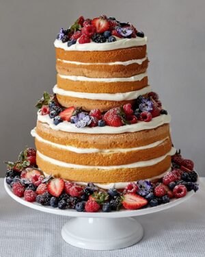 Martha Stewart Instagram - End your Fourth of July celebration with a showstopping dessert, like our naked berry chiffon cake. You don't need frosting to create a spectacular confection; instead, Martha adorns this eight-layer beauty with fresh berries, edible flowers, and powdered sugar. Get the recipe at the link in our bio. 📷: Mike Krautter