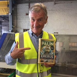 Michael Palin Instagram - The book is born. At Clay’s the printers in Suffolk with the first copy to come off the presses. It’s a very dangerous and noisy book, hence the ear-plugs and High-Vis jacket.