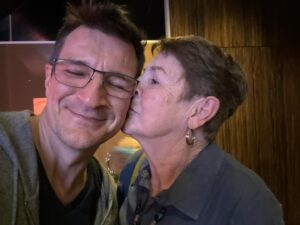 Nathan Fillion Instagram - This is my mom, God rest her soul (not dead). I can say with certainty that I get my outlook on life from her. She taught me that the difference between lucky and unlucky people is gratitude. When things look bad, she’s been known to say, “At least you’ve got legs.” And she’s right. I do. In her eyes, there’s always something to be celebrated, always something to be thankful for, and always enough love to go ‘round. I’m ever so grateful for being raised by this lady, and for her influence that runs strong throughout my family. Today is your day, Cookie. See you this afternoon.
