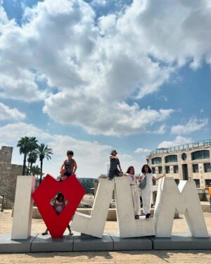 Noa Tishby Instagram - There’s no place like #jerusalem. Every time I’m in Israel we spend a few days in this magical city with friends and family. And today it’s more important than ever... 

As soon as we got to the hotel I heard an incredible group of reservists wives is there for a conference @mamatcal1 so I had to pop in, spend some time together and see how these brave lionesses are holding us all up. (And hold a cute baby too :) 

We went to the rooftop of @mamillahotel for sunset drinks and from there to the Food Truck Festival @autochel_je and a laser show over the old city. Next day we spent time at the new and renovated National Library @nli_israel with ancient and modern Jewish literature. Next we went to the Hebrew music museum @hebrew_music_museum where the kids (ok, the adults too) got to play old and new instruments. Shabbat dinner was stunning at Chakra restaurant. @chakrarest Beyond delicious fusion Israeli food. The next day we walked the old city again and got to climb all the way to the top of the ancient minaret at @towerofdavid! It held up well. Thank G :) 

And yeah, Ari chose that shirt on his own 😂 

Can’t wait to be back, I💙JLM 

Thank you for everything as always @itraveljerusalem @reutf81 @asia.spectour 
 
אין על ירושלים…. בכל פעם שאני פה אני מקפידה לעשות טיול בעיר המהממת שלנו - והיום זה אפילו יותר חשוב מתמיד. כשהגענו אמרו לי שיש במלון קבוצה של נשות מילואים בחופשה עם ארגון נפלא שנקרא ממטכ״ל אז הלכתי לפגוש אותן ולעזור להחזיק תינוק, כי זה מה שצריך לעשות לאשת מילואימניק שסוחבת הכל על גבה לבדה. הן היו מדהימות אריות (לא לביאות! אריות!!) מעוררות השראה. 

בילינו שלושה ימי קסם בעיר הקסומה הזאת. מלון ממילא היה מהמם עם שקיעה מדהימה כתמיד. אוטואוכל זה גאוני והילדים אכלו רקדו רצו להם והשתוללו עד מופע הלייזרים מעל העיר העתיקה. למחרת נסענו לספרייה הלאומית והיה פשוט עוצר נשימה חובה להגיע גם הילדים נהנו. מוזיאון המוזיקה היה מקסים. בערב הלכנו למסעדת צ׳אקרה וטרפנו אוכל מושלם. למחרת טיילנו שוב בעיר העתיקה קניתי זעתר ותבלין שווארמה והסכמתי שארי יקנה את החולצה האדומה הזאת כי… כי זה לא לא נכון 😂 אני אוהבת את ירושלים כל כך… לא יכולה לחכות לחזור שוב. 💙💙💙💙💙.