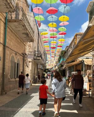 Noa Tishby Instagram - There’s no place like #jerusalem. Every time I’m in Israel we spend a few days in this magical city with friends and family. And today it’s more important than ever... 

As soon as we got to the hotel I heard an incredible group of reservists wives is there for a conference @mamatcal1 so I had to pop in, spend some time together and see how these brave lionesses are holding us all up. (And hold a cute baby too :) 

We went to the rooftop of @mamillahotel for sunset drinks and from there to the Food Truck Festival @autochel_je and a laser show over the old city. Next day we spent time at the new and renovated National Library @nli_israel with ancient and modern Jewish literature. Next we went to the Hebrew music museum @hebrew_music_museum where the kids (ok, the adults too) got to play old and new instruments. Shabbat dinner was stunning at Chakra restaurant. @chakrarest Beyond delicious fusion Israeli food. The next day we walked the old city again and got to climb all the way to the top of the ancient minaret at @towerofdavid! It held up well. Thank G :) 

And yeah, Ari chose that shirt on his own 😂 

Can’t wait to be back, I💙JLM 

Thank you for everything as always @itraveljerusalem @reutf81 @asia.spectour 
 
אין על ירושלים…. בכל פעם שאני פה אני מקפידה לעשות טיול בעיר המהממת שלנו - והיום זה אפילו יותר חשוב מתמיד. כשהגענו אמרו לי שיש במלון קבוצה של נשות מילואים בחופשה עם ארגון נפלא שנקרא ממטכ״ל אז הלכתי לפגוש אותן ולעזור להחזיק תינוק, כי זה מה שצריך לעשות לאשת מילואימניק שסוחבת הכל על גבה לבדה. הן היו מדהימות אריות (לא לביאות! אריות!!) מעוררות השראה. 

בילינו שלושה ימי קסם בעיר הקסומה הזאת. מלון ממילא היה מהמם עם שקיעה מדהימה כתמיד. אוטואוכל זה גאוני והילדים אכלו רקדו רצו להם והשתוללו עד מופע הלייזרים מעל העיר העתיקה. למחרת נסענו לספרייה הלאומית והיה פשוט עוצר נשימה חובה להגיע גם הילדים נהנו. מוזיאון המוזיקה היה מקסים. בערב הלכנו למסעדת צ׳אקרה וטרפנו אוכל מושלם. למחרת טיילנו שוב בעיר העתיקה קניתי זעתר ותבלין שווארמה והסכמתי שארי יקנה את החולצה האדומה הזאת כי… כי זה לא לא נכון 😂 אני אוהבת את ירושלים כל כך… לא יכולה לחכות לחזור שוב. 💙💙💙💙💙.