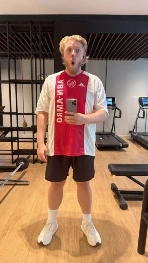 Rob Beckett Instagram - I didn’t make the gym last week. A combo of lack of time in the summer holidays and doing 2 days of Gladiators which destroyed me emotionally and physically for about a week. 🤣🤣🤣. Today I’m wearing an Ajax home shirt from 2005/2006. Always loved Ajax and the kit because of Dennis Bergkamp and that Davids and Seedorf era of player was 🤌🏻🤌🏻🤌🏻. Also for some weird reason I always thought the sponsor looked so cool and Dutch. I was incredibly disappointed when I realised it was just the name of a bank written vertically. Still haven’t seen Ajax play. It’s on my football bucket list. My question to you is? Best player to wear this kit. Not play for Ajax but play in this actual kit from 2005/26. Answers below 👇🏼👇🏼
