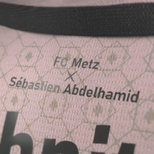 Sébastien-Abdelhamid Godelu Instagram - @fcmetz X Sebastien Abdelhamid ! 
Un honneur et une fierté immense pour moi de signer ce maillot third pour ce club qui représente tant pour moi. 

Ce maillot est une déclaration d’Amour au club, à la ville et ses habitants ! 🇱🇻

Je me suis replongé dans ce qui m’avait marqué et tant séduit (au-delà des gens) quand j’ai découvert Metz dans mon enfance : son architecture, la place Saint-Louis, les arcades, l’influence italienne, la Renaissance. Metz est une ville de culture avec une grande histoire.

C’est vraiment ce qui a guidé mon inspiration. En ce sens, j’ai voulu travailler un élément iconique, emblématique et ô combien symbolique (surtout en ce moment) : la croix de Lorraine. J’en ai fait un monogramme qui conjugue toutes ces inspirations architecturales et culturelles citées plus tôt.

Il restait à déterminer la couleur, qui doit trancher avec le Home et l’Away tout en ayant un sens pour garder un ensemble cohérent. Le rose est inspiré de la colonne de Merten, ce qui donne à l’histoire de ce maillot un vrai ancrage dans la ville et une sorte de voyage en son sein.

J’espère qu’il vous plaira, il est à vous, il est à nous désormais ❤️

Un rêve de gosse qui se concrétise, mon premier stade, premier match, premières émotions de foot voyant @robert_pires07 fouler la pelouse.
une énorme émotion derrière ce projet qui symbolise tant pour moi. Croyez en vous, croyez en vos rêves ! 

Un ÉNORME merci au @fcmetz pour la confiance et le plaisir de collaborer ensemble tout au long du processus creatif, merci à toutes les équipes vraiment. Un Énorme merci et bravo en particulier à @juliedkr57 et @annelmrqs qui ont fait un boulot fantastique et elles sont clairement au cœur de ce projet.

Grand Merci à @benhofame qui a permis de consolider ce projet et de le lancer !

Merci @kappa_sport 

Merci à toute la team @hype_noticefr qui s’est défoncée pour produire des contenus au top.

#collab #collaboration #foot #fcmetz #metz #maillot #Pireslegoat #KastendeuchLaLegende