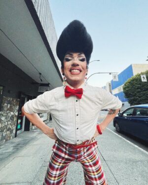 Vivian Vanderpuss Instagram - Do these pants make my legs look lithe? 
Some fab little shots from Wigstock during Pride week @theviciouspoodle with Woofie (@seanburgundy ) 
It was the third show of the day so we went heavy with the filter ha! 
✨
I made this wig a long time ago and it’s been sitting on my shelf waiting for the perfect character. I was a game show host, a biker, a little Freddie and a phantom in one eve. I wasn’t sure (with how big this hat was) how it would hold up doing 5 numbers real quick but it was perfectly fine! God bless hairspray and a good tease! 
✨
The hair is inspired by Wooden Sword Ryu from Shaman King! 
.
.
.
.
#drag #dragking #dragkingmakeup #vivianvanderpuss #wig #dragwig