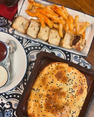 Renaye Tejani Instagram - Had the yummiest meal at @cafemommyjoon , and I’m still craving every bite 😋✨ 
Here’s what I devoured:

- Cheesy Lamb Koobideh Bite 🧀
- Chicken Stuffed Barbari 🍗
- Hummus & Pita 🥙
- Pallonji Raspberry 🍒
- Lemonade 🍋
- Tahcheen E Gusht 🍛
-Cocoa Walnut Baklava 🍫
-Fereni 🍚

Thank you so much for inviting me @cafemommyjoon 
What would you like to try ? 
Let me know below!