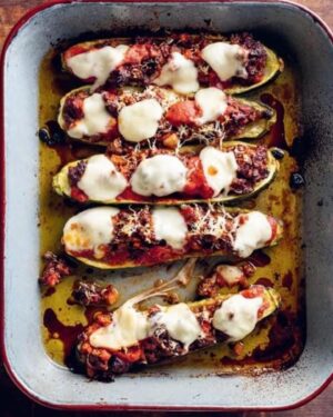 Silvia Colloca Instagram - Publication day!!!
My 7th book, ITALIAN FAMILY FOOD is out in all bookstores and online! 
Thanks a million to those who pre ordered and have already started cooking from it!
To celebrate, here is a lovely recipe of Bolognese stuffed zucchini for you!
My zucchini-hating son has now started loving them because of this recipe! 😂💕

Serves 4
 
4–5 zucchini
freshly grated pecorino, to serve
3/4 cup bocconcini

Bolognese sauce

3 tablespoons extra-virgin olive oil
1 onion, chopped
1 carrot, chopped
1 celery stalk, chopped
1 garlic clove, skin on, bashed with the back of a knife
500 g pork and veal mince 
200 ml red wine
400 g can chopped tomatoes
500 ml (2 cups) good-quality beef or chicken stock
1–2 bay leaves
salt flakes and freshly ground white pepper
 
To make the bolognese sauce, heat the olive oil in a heavy-based saucepan over medium heat. Add the onion, carrot, celery and garlic and cook until the onion is soft and translucent. Drop in the pork and beef mince and brown over high heat for 5 minutes, breaking up any lumps as you go.
Deglaze the pan with the wine, scraping up any bits caught on the base, and simmer away until the alcohol has evaporated, about 2 minutes. Pour in the tomatoes and stock, bring to a simmer, then reduce the heat to low. Add the bay leaves, season with salt and cook, covered, for 4–6 hours, stirring occasionally, until rich and slightly reduced. If the ragù starts to dry out, add a little water. Taste for salt and adjust accordingly, and season with pepper.
Preheat your oven to 200°C (180°C fan-forced). Line a baking tray with baking paper.
Cut the zucchini in half lengthways. Using a spoon, hollow out the flesh without cutting through to the base. Reserve the zucchini flesh for a later use (great in soups!).
Fill the hollowed-out zucchini halves with the bolognese sauce, sprinkle with the pecorino and arrange on the tray. Bake for 25–30 minutes, then scatter the bocconcini on top and bake for a further 5–10 minutes until golden and delicious.

Thank you to my glorious team at @panmacmillan for making this happen!