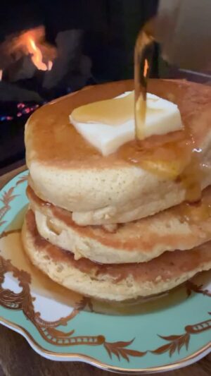 Damaris Phillips Instagram - I’m spending my snow days cooking and reading by the fire. It’s like the holidays got extended for a bit longer. 
Soufflé Pancakes
Ingredients:
3 eggs, separated 
1/4 cup granulated sugar 
1/2 cup cake flour (AP flour works too) 
1/2 teaspoon baking powder 
1/8 teaspoon salt 
3 tablespoons whole milk (or any milk you like) 
1 teaspoon vanilla extract 
2-4 tablespoons water for cooking 
Butter for cooking 

Tools:
12-inch skillet (nonstick or cast iron with deep sides) 
Lid for the skillet 
hand mixer or stand mixer 
Optional: 1 ounce cookie scoop 

Method: 
Separate the eggs. Reserve the whites for later. Start by whisking the egg yolks, milk, and vanilla together.  Add the flour, baking powder, and salt to the egg yolk mixture. Stir until smooth and set aside. 

Using a hand or stand mixer, beat the egg whites with your until frothy. Gradually add the sugar and continue whipping until you reach stiff peaks. (Stiff peaks are important!)

Set your skillet on low heat, adding a small pat of butter. Let it melt while you prep the batter. 

Gently fold a third of the whipped egg whites into the egg yolk mixture. Once it’s combined, fold in the rest of the egg whites carefully—no overmixing! 

Scoop 3-4 portions of batter into your warm skillet, spaced out (use a cookie scoop or spoon). For extra fluff, add another scoop of batter on top of each pancake. 

Carefully pour 1 tbsp of water into the skillet, avoiding the batter, then cover with the lid. Set a timer for 2 minutes.  After 2 minutes, uncover the skillet and add another scoop of batter onto each pancake. Replace the lid and cook for another 4-5 minutes on low-medium heat. 

Once the bottom is golden brown, carefully flip the pancakes. Add another tbsp of water to the skillet, cover, and cook for 4 more minutes until the bottom is golden and the sides are dry. 

Repeat for the remaining batter, adjusting heat as needed to avoid burning.