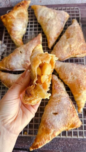 Laura Vitale Instagram - Buongiorno!! These apple turnovers are unreal but oh so easy!! I simply peel and dice about 5 apples, sautee them in a couple tablespoons of butter and 1/3 cup of brown sugar with a splash of vanilla and a little orange zest, touch of cinnamon and couple tbsp of flour for about 5ish minutes. Then I let them cool, roll out a couple sheets of thawed puff pastry, cut each sheet into 4 squares, dollop a little apple mixture in each one, fold over into a triangle, seal, then pierce the top a little for the steam to escape, brush a little egg wash and sprinkle a touch of sugar. Bake at 400 for 20ish minutes or until golden brown. Serve as is or if you dare, top with a scoop of ice cream and a drizzle of salted caramel.  GOODBYEEE!! 😍😍