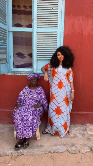 Nia Pettitt Instagram - I didn’t get to meet my Grandmother as she died before I was born. When I arrived at Gorée Island I saw this beautiful Queen selling some traditional Senegalese desserts and I admired her from afar. Hours later, @hawo_kane arrived and we wandered around shooting. I coincidentally packed this dress I bought at a market the day before and when Hawo began speaking to Ms. Fatou, she began complimenting me and allowed me to shoot with her. I remembered my dress and had a desire to wear it l. I didn’t have anywhere to change but she let me into her home. In that short encounter, I got a glimpse into my African Grandmothers love. It felt so safe and warm. I didn’t plan to shoot this at all but the photos that we took together are my favourite of all time. Thank you Ms. Fatou for this sentimental memory I won’t ever forget. 🌞✨💛🇸🇳 #Senegal #niaTHELIGHT