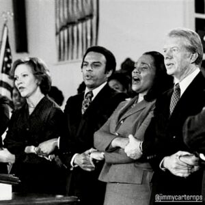 Isabel Wilkerson Instagram - What was Jimmy Carter trying to teach us in taking his final bow at this pivotal moment in America? That there is, in fact, goodness and decency in the world when we fret that there is none. That even out of power, and perhaps especially more so out of power, people can do great good in the world, if we can find our purpose and calling. That wise and measured sacrifices on behalf of the whole, as with the restraint shown during the Iranian hostage crisis which ultimately yielded their safe release, can achieve the desired goal, or that visionary moves that may seem quirky at the time, like solar panels on the White House way back in the 1970’s, may take decades to be affirmed, but affirmed they will be. That patience, kindness, compassion and tenacity are superpowers that take time to bear fruit, but last beyond the whims of any moment and can have more power than naked dominance. 

Who would not want the genuine, abiding love that he and Rosalynn had, that perhaps few people ever truly get to know, that lasted longer than many people get to live, or the long and purposeful life he himself achieved.  He offered all of us a redefinition of success on his own terms. 
By his actions in defeat, he singularly forced a reassessment of his presidency and of his role in history, assuring that he will be remembered longer than his one term in the White House would suggest on its own.  Which is why regular folks in Washington, D.C., lined up in the bitter cold and waited for hours to pay their respects to him, as his remains laid in state in the capitol rotunda last night. He taught us that defeat is not the end but the beginning. He left us a blueprint for how to harness life’s disappointments into the greatest and longest lasting gifts for ourselves and for the world. 
——
Slide 1: Rosalynn Carter, Andrew Young, Coretta Scott King, Jimmy Carter
Slide 2: With John Lewis
Slide 3: Carter on MLK’s legacy
Slides 4, 5: With Rosalynn Carter
Slide 8: Greeting every passenger on a Delta Airlines flight, as was his way
Slides 9, 10: People lined up in DC, via Joy Reid