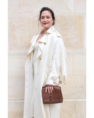 Lily Gladstone Instagram - Our dear friend @lilygladstone attending our Spring Summer 2025 show in Paris.
Lily wears an ivory textured linen slub Casper trench coat with watteau-back detail and ivory cashmere Knite knit dress from the Spring Summer 2025 paired with the cognac nappa leather Bocca boot and the chocolate nappa leather medium Leonora flap bag