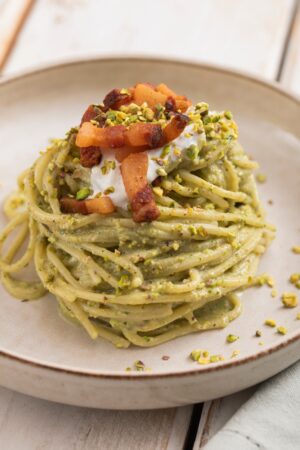 Ludovica Gargari Instagram - 🍝Il Piatto vincente di...
@matteozurlonss, climber olimpico campione olimpionico di speed arrampicata con record europeo🏆💚 Tonnarelli con pistacchio, guanciale e stracciatella😋 Non perdetevi assolutamente questa ricetta!🥰
@lulugargari @giallozafferano 

Ingredienti:
100g di tonnarelli
100g di pistacchi sgusciati
75g di guanciale
25g di stracciatella di burrata
Limone q.b.
Basilico q.b.
Olio q.b.
Formaggio grattugiato q.b.
Granella di pistacchi q.b.
Sale q.b.

Preparazione:
Tagliamo il guanciale a striscioline e rosoliamolo in padella fino a renderlo croccante. Scoliamo su carta assorbente e teniamo da parte l’eccesso rimasto in padella.
In un frullatore versiamo il basilico, l’eccesso di grasso del guanciale, i pistacchi, il formaggio grattugiato, il sale e l’olio. Frulliamo fino a ottenere una crema omogenea. 
Cuociamo i tonnarelli in acqua salata e, una volta cotti, li trasferiamo nella padella dove abbiamo cotto il guanciale. Aggiungiamo il pesto e mescoliamo per amalgamare i sapori. Aggiungiamo poi il guanciale croccante e mescoliamo.
Tocco dello chef: aggiungiamo la scorza di limone alla stracciatella di burrata e mescoliamo. Impiattiamo creando un nido di pasta nel piatto, aggiungiamo la stracciatella con la scorza di limone. Completiamo con qualche strisciolina di guanciale e granella di pistacchi! Buon appetito😋

@dao_sport 

#giallozafferano #ricette #olimpiadi #atleti #arrampicata #matteozurloni #cucina #pasta #pistacchi