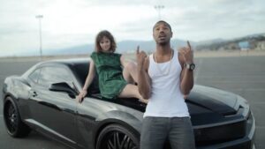 Sarah Ramos Instagram - This clip is from a music video I directed 9 years ago for @landonpigg‘s cover of @thereallfo song Girl On TV featuring @michaelbjordan & my ahead-of-their-time curly bangs that NBC made me get rid of. Contrary to internet urban legend, this was not MBJ’s attempt at a rap career. It was purely my unhinged nature. Never change!