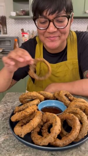 Sohla El-Waylly Instagram - Nori Tempura Onion Rings

For the batter:
4 0.14 ounce packages roasted seaweed
¾ cup all-purpose flour
¼ cup tapioca starch, cornstarch, or glutinous rice flour 
2 tablespoons sesame seeds
1 teaspoon baking powder
1 teaspoon kosher salt
1 cup sparkling sake or beer
1 tablespoon soy sauce
1 tablespoons roasted seame oil

For the onion rings:
1 large yellow onion
⅓ cup all purpose flour
Neutral oil, such as peanut or safflower
Kosher salt

In a spice grinder, blitz the nori sheets into a powder. 

Whisk together the flour, starch, sesame seeds, baking powder, salt, and ground nori. 

In a small container, combine sake, soy, and sesame oil. Whisk into the dry mixture just before frying. 

Peel the onion, slice into ½-inch thick rings, and separate the layers into a large bowl. Toss with flour.

Add enough oil to come 2-inches up the sides of a heavy pot or Dutch oven. Heat to 375F. 

Dip each floured onion ring into the batter, flip to evenly coat, then carefully lower into the hot oil. Fry 3 to 5 rings at a time, flipping once, until crispy and browned. 

Sprinkle with salt while hot! Serve with okonomi sauce.
